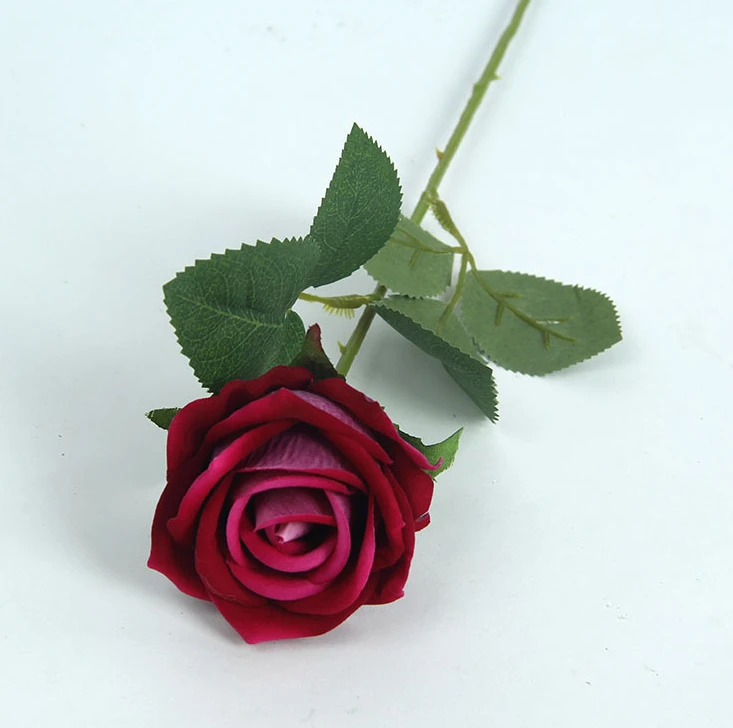 A single red artificial rose with a long green stem