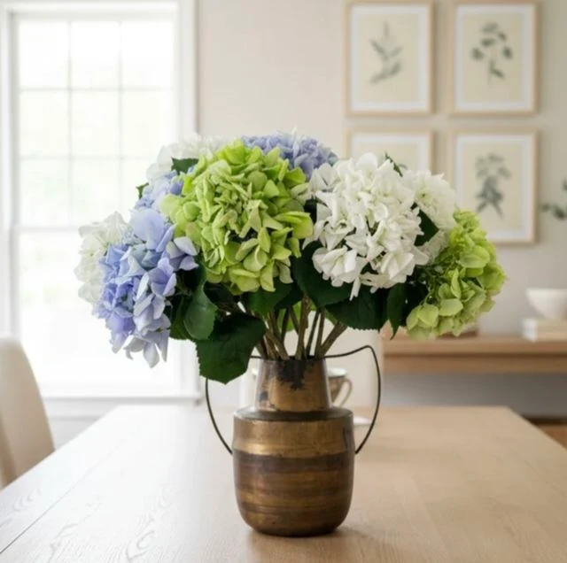White, green and blue artificial hydrangeas styled in a vase