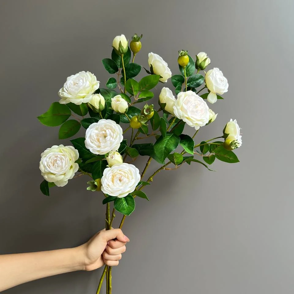 White artificial rose-style flowers and buds on branching green stems