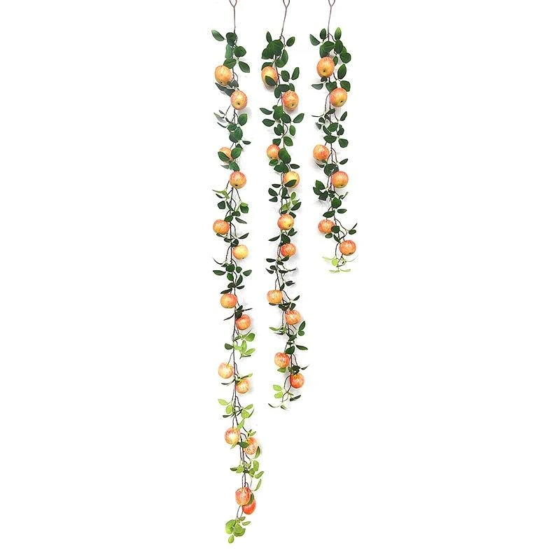 Long artificial green leaf vines with small pale orange fruit ornaments
