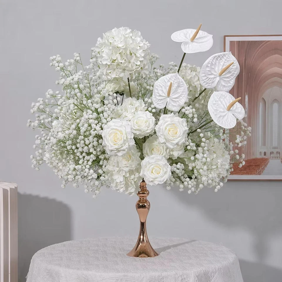 White artificial baby’s-breath and other flowers on a decorative gold pedestal