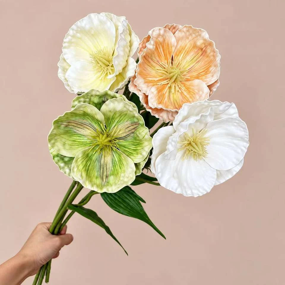 White, green and peach artificial flowers with broad ruffled petals held by their stems
